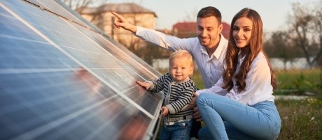 Familie vor Solaranlage ihres Hauses