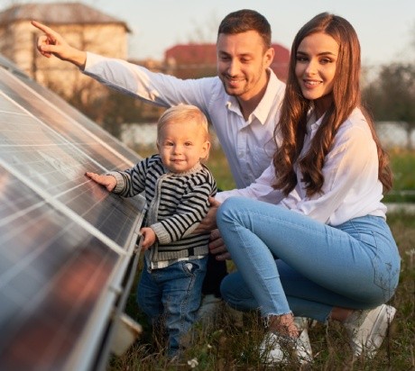 Familie vor Solaranlage ihres Hauses