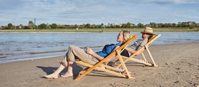 Mann und Frau sind ganz entspannt am Rheinufer