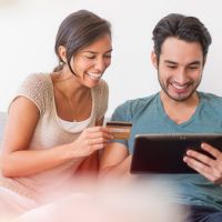 Mann und Frau bezahlen mit Kreditkarte im Internet